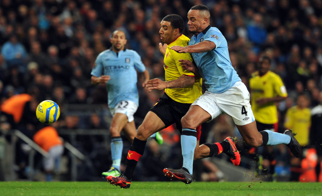 Troy Deeney battles with Man City legend Vincent Kompany.
