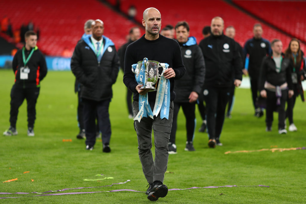 Manager of Manchester City, Pep Guardiola holds the trophy