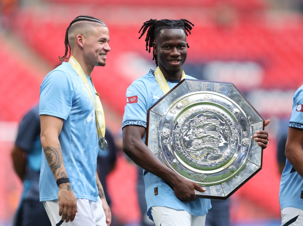 Kalvin Phillips and Issa Kabore of Manchester City celebrate with the trophy after the 2024 FA Community Shield match between Manchester United and Manchester City at Wembley Stadium on August 10, 2024