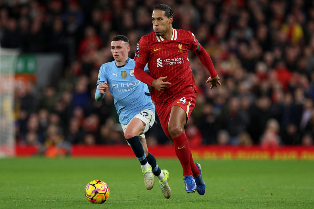 Virgil van Dijk running with the ball with Phil Foden chasing him