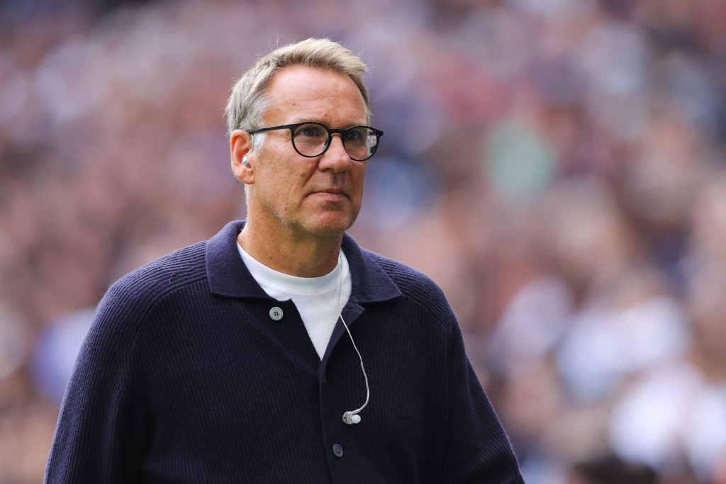Paul Merson walking while doing punditry work.