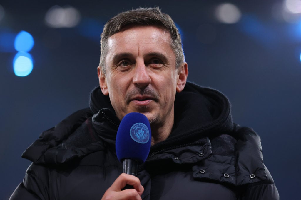 Gary Neville speaking into a Man City branded microphone.