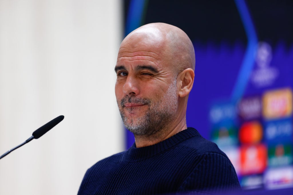 Pep Guardiola winks during a press conference for Manchester City.