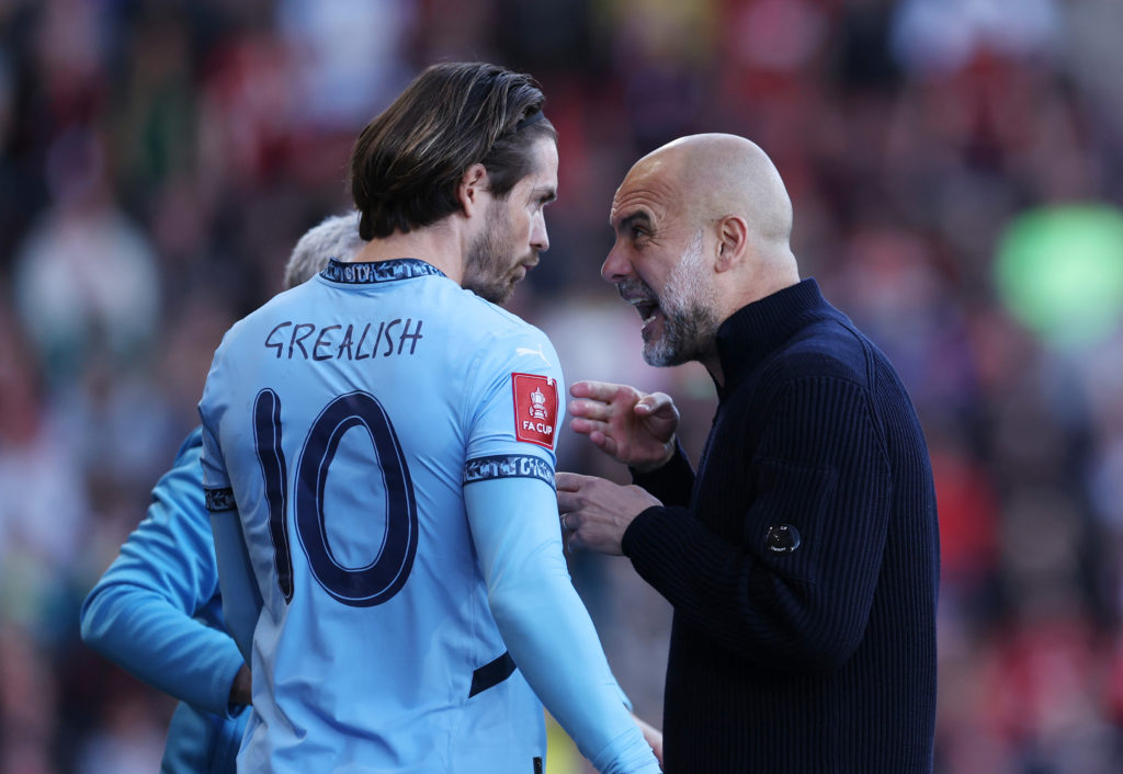 Man City manager Pep Guardiola giving instructions to Jack Grealish.