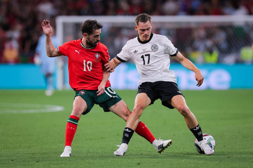 Florian Wirtz and Bernardo Silva contest the ball in Germany v Portugal.