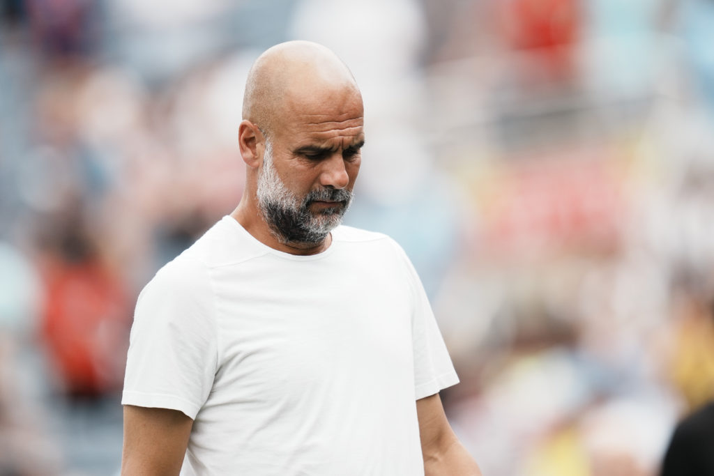 Man City manager Pep Guardiola with his head down.