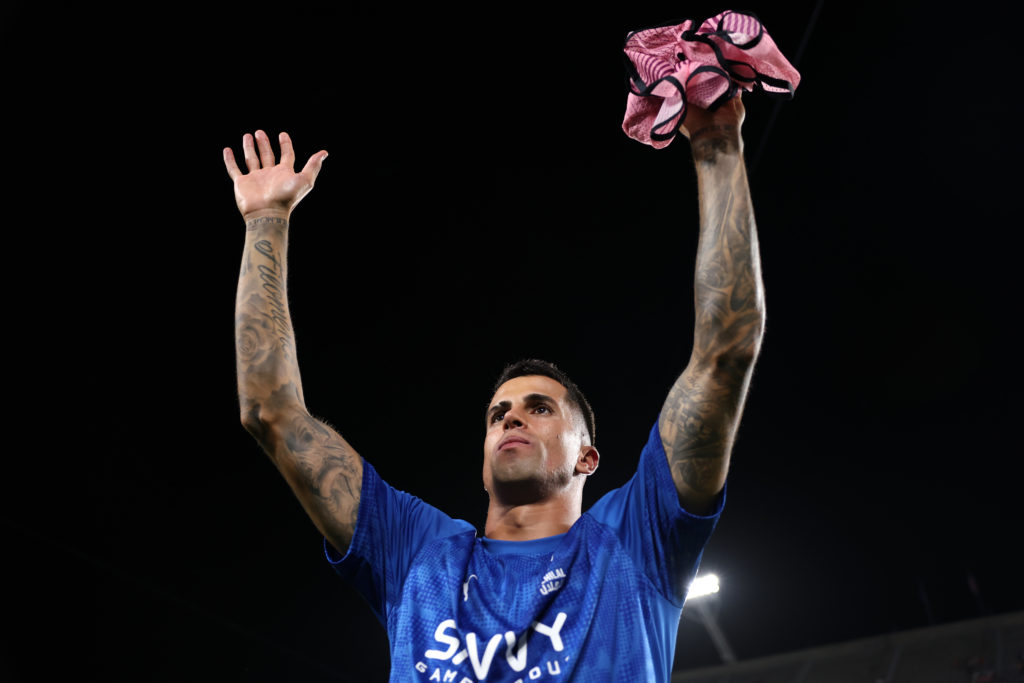 Joao Cancelo holds his arms aloft.