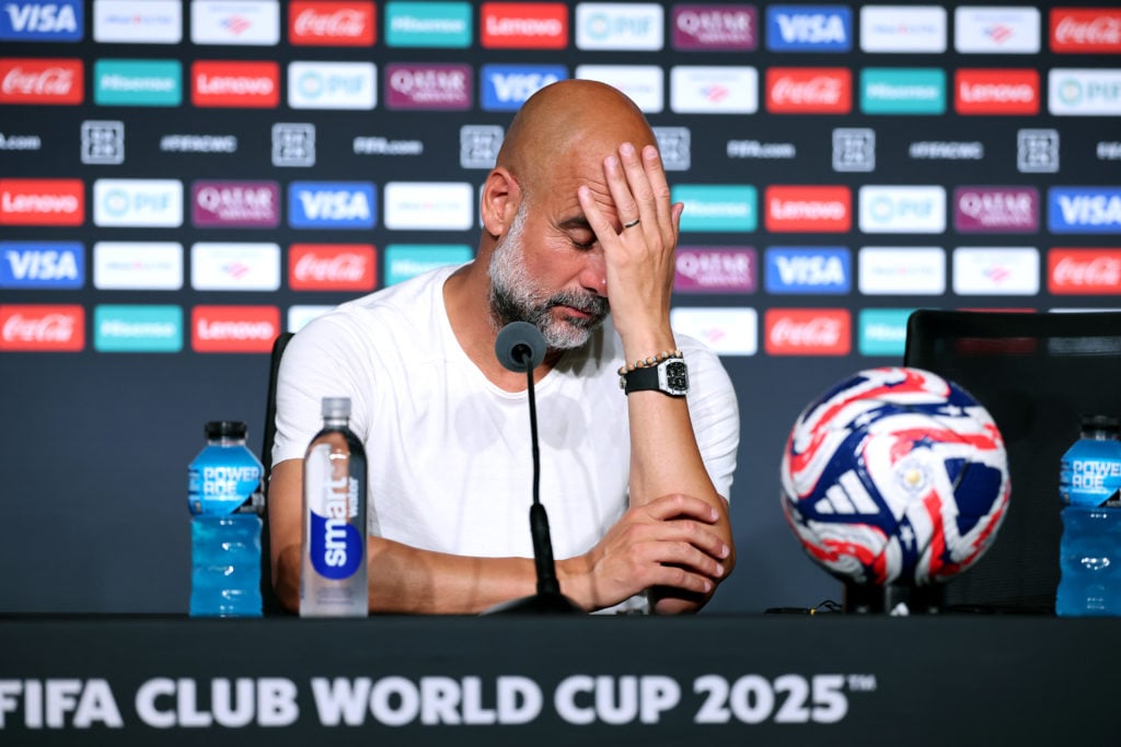 Pep Guardiola with his hand on his face during a Man City press conference.