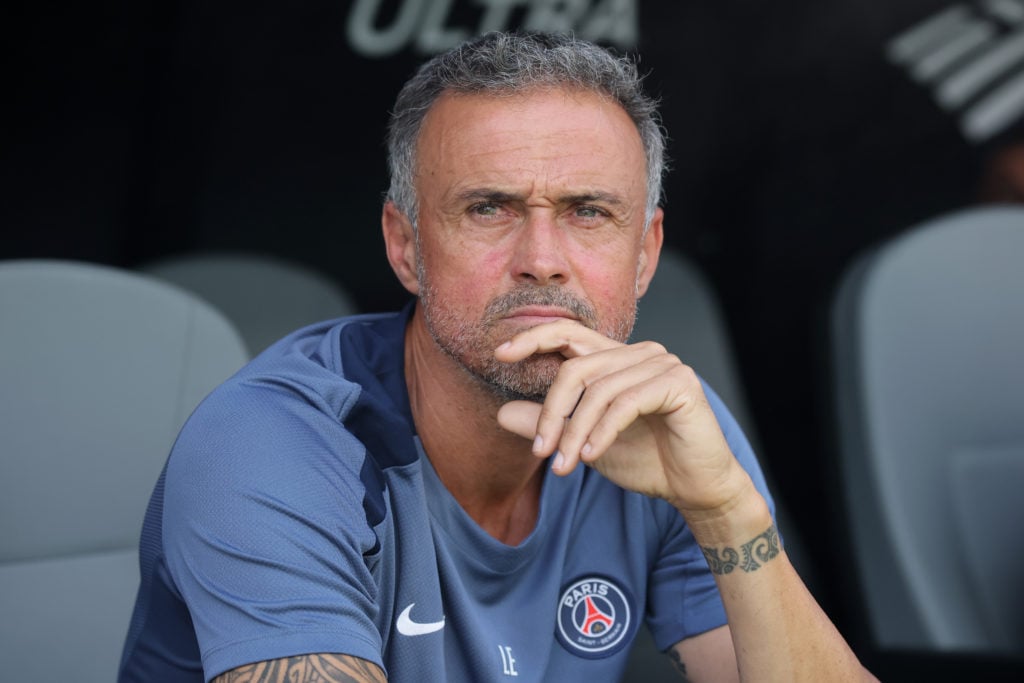 Luis Enrique thinking on the bench during a PSG match.