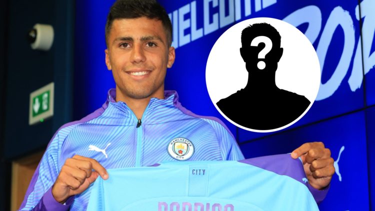 Manchester City's new signing Rodri displays his shirt during a press conference at the Etihad stadium in Manchester, mystery figure inset