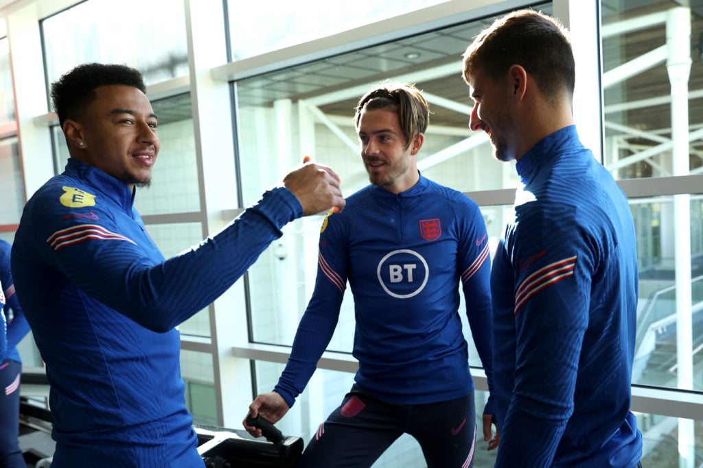 Jesse Lingard, Jack Grealish and Mason Mount talk during a training session in the gym at St Georges Park on October 06, 2021