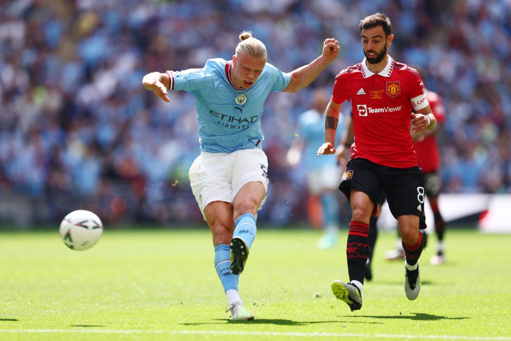 Erling Haaland of Manchester City shoots whilst under pressure from Bruno Fernandes of Manchester United during the Emirates FA Cup Final between Manchester City and Manchester United at Wembley Stadium on June 03, 2023