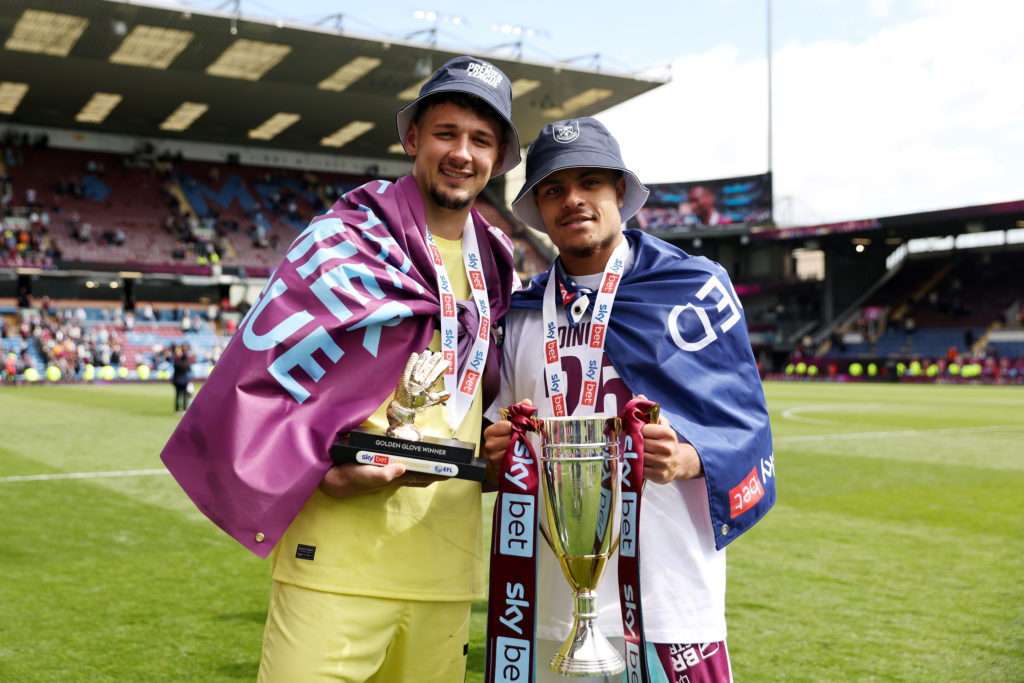 James Trafford of Burnley holds his golden glove trophy as he poses for a photo with teammate CJ Egan-Riley of Burnley who is holding the Sky Bet Championship runners up trophy, after the teams 3-1 victory in during the Championship match between Burnley FC and Millwall FC at Turf Moor on May 03, 2025 in Burnley, England.