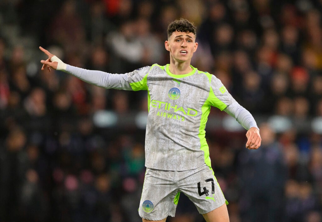 Phil Foden points while playing for Manchester City.